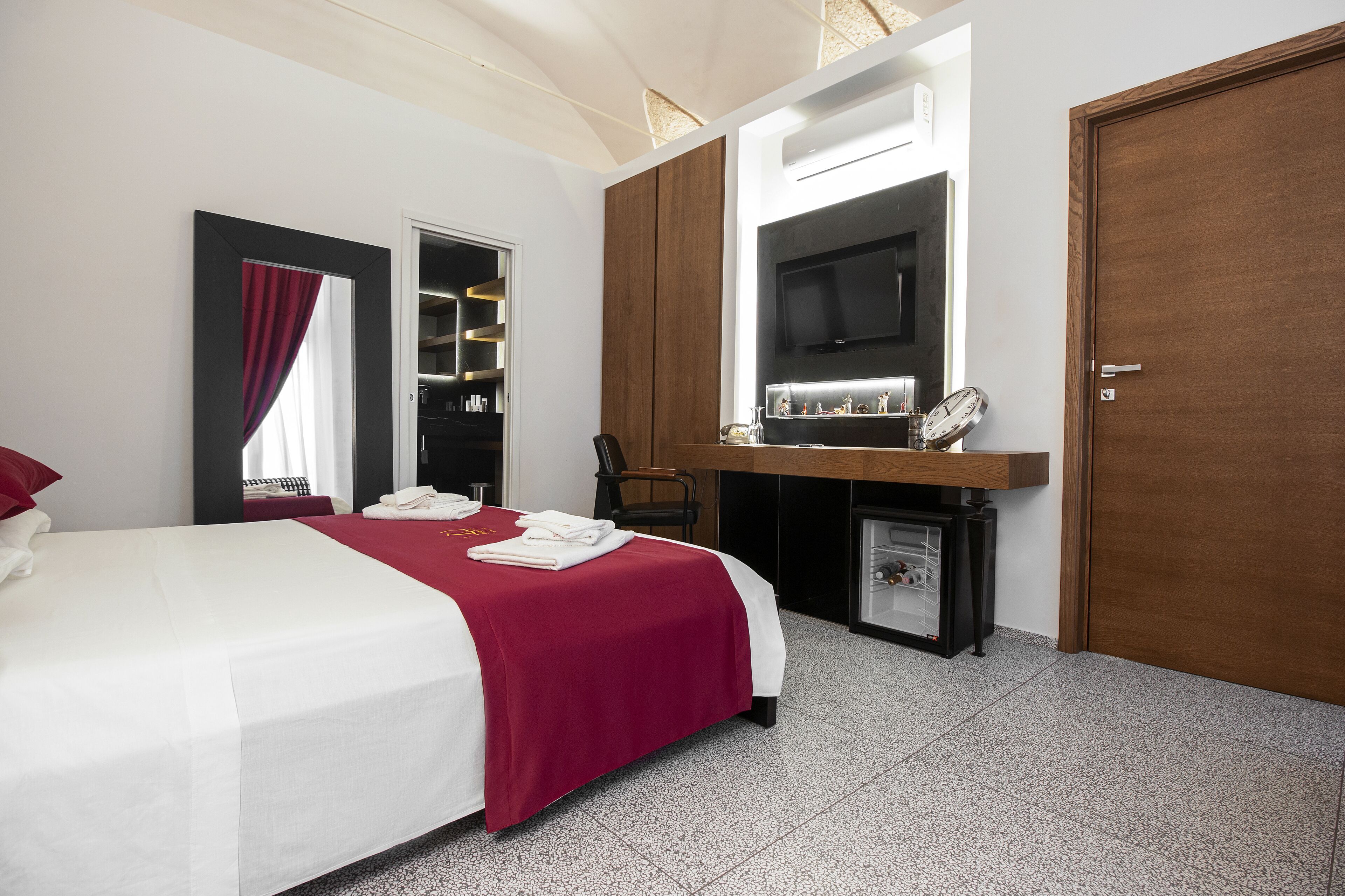 Une chambre d’hôtel équipée d’un lit, d’un bureau, d’une télévision et d’une armoire.