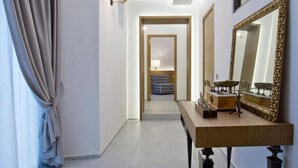A hallway with a wooden console table, a large mirror, and a view into another room. - Annunziata Guesthouse, Centro Storico (Naples)
