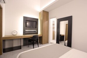 Sengetøy av topp kvalitet, dundyner, minibar og safe på rommet