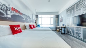 Habitación de hotel con dos camas, un escritorio, una silla y un ventanal grande.