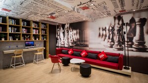 A modern library with bookshelves, a red sofa, and a chessboard mural. - Ibis Nanchang Bayi Museum Metro Station Hotel Hotel (Nanchang)