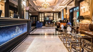Un lobby lujoso con una espectacular lámpara de araña, un mostrador de recepción y elegantes muebles.