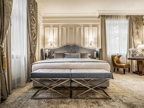 A large bed with a tufted headboard, a bedside table, and a lamp. - Bachleda Luxury Hotel Kraków - MGallery Collection (Kraków)