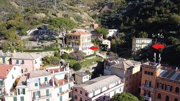 A hillside residential area with buildings featuring balconies and terraced roofs.