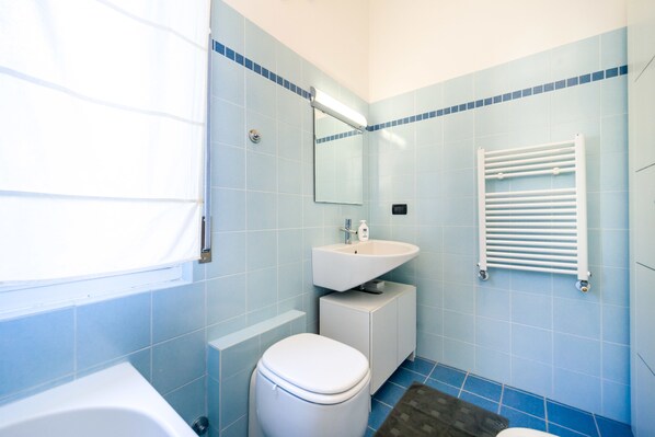 Un baño con inodoro, lavamanos y bañera.