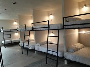 Bunk beds with attached ladders, each with a wall-mounted light. - Hostal Inn - Hostel (Playa del Carmen)