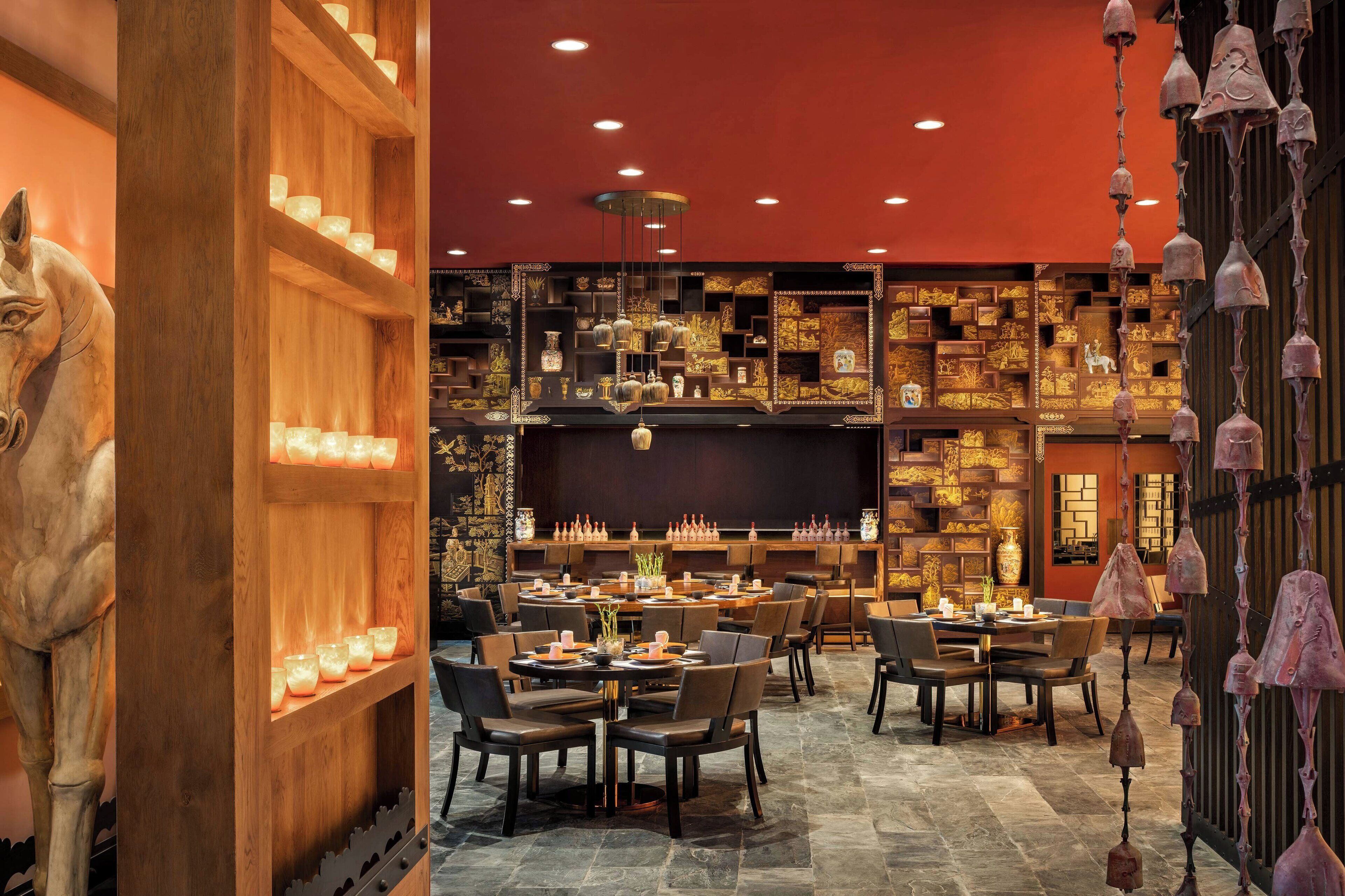 A restaurant with wooden shelves and tables, a large horse sculpture, and hanging bells.