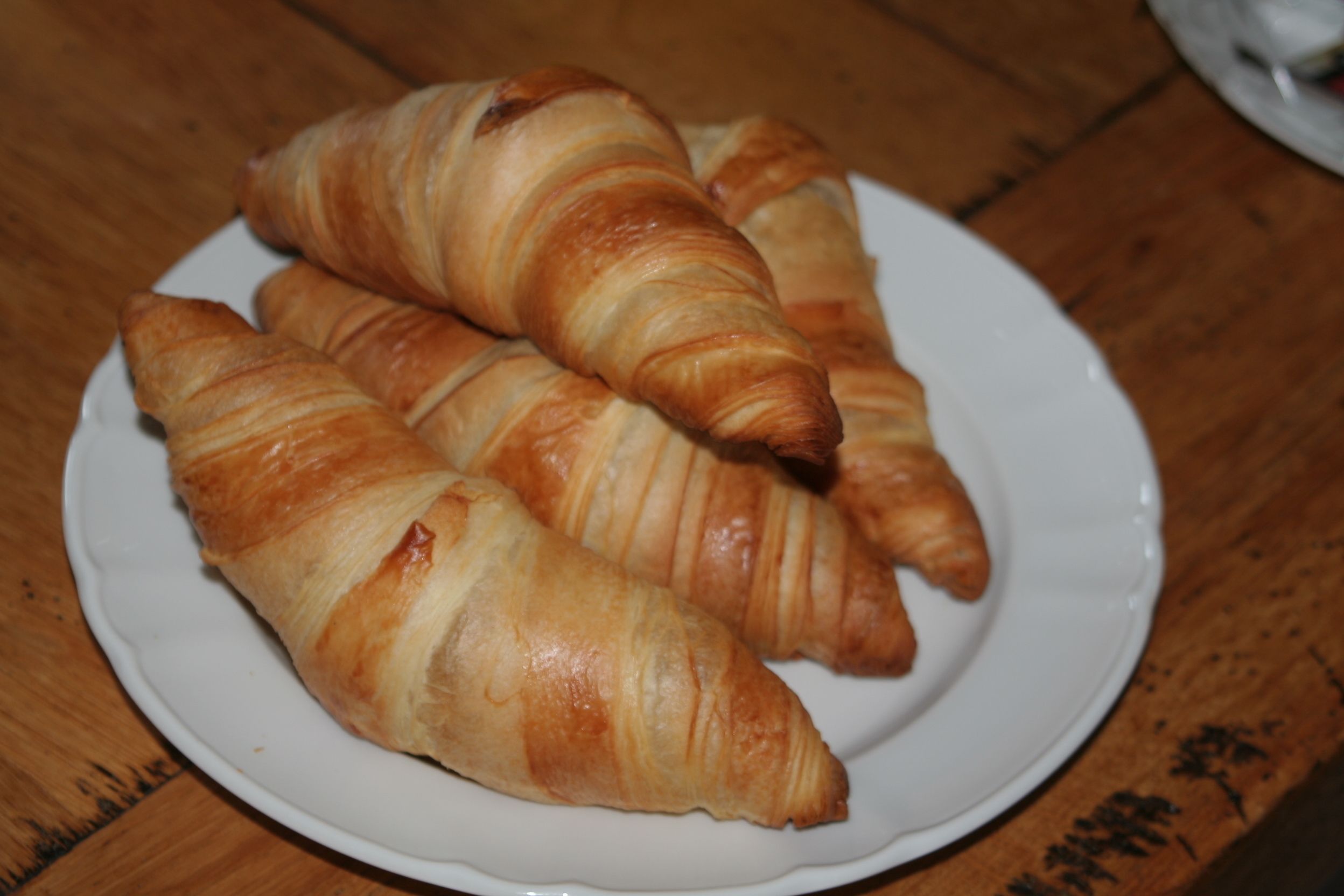 Three croissants on a white plate.