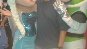 A person in a blue and white costume with a character in a green and white costume.