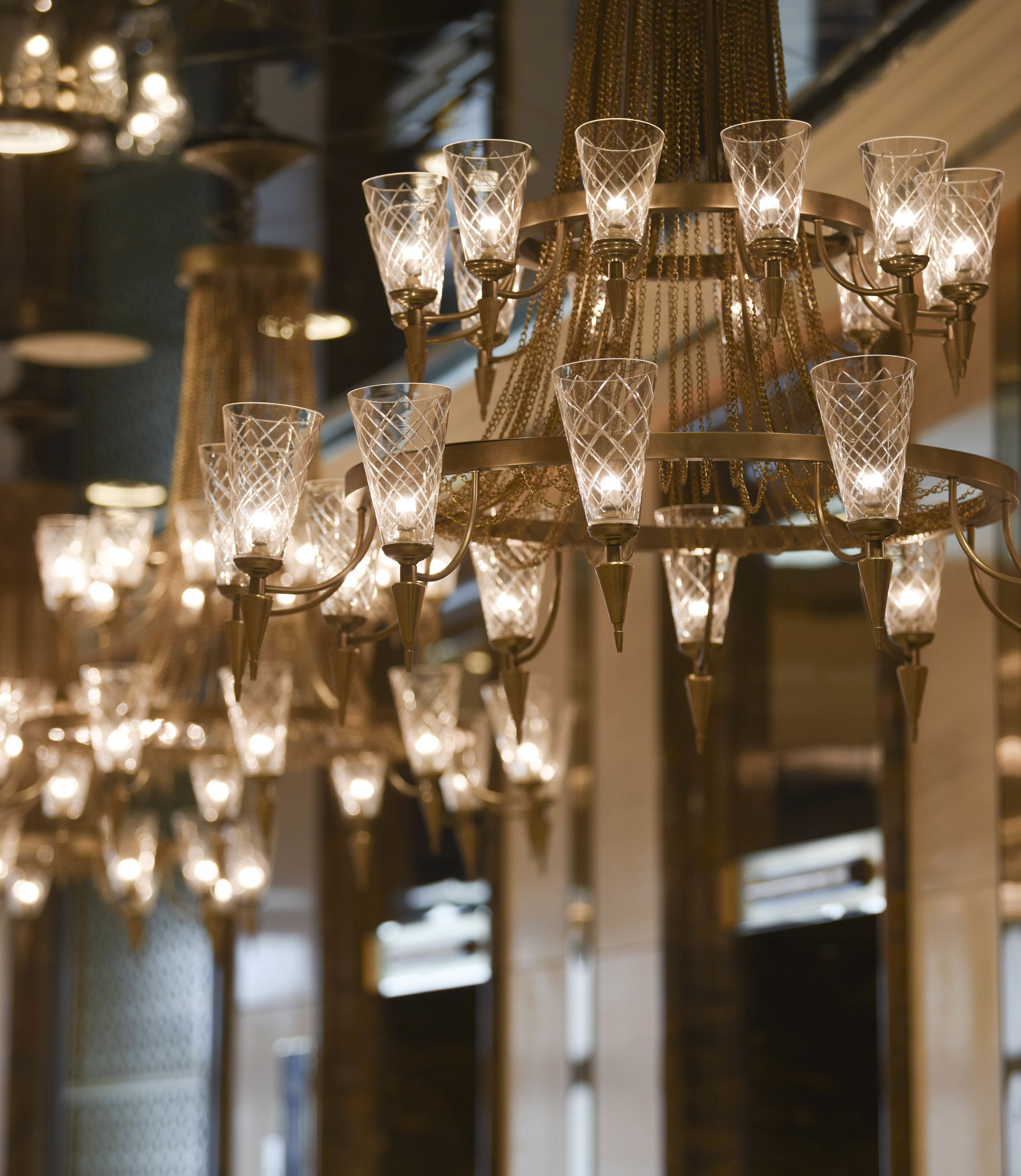 Um candelabro com várias cúpulas de vidro e acabamento metálico.