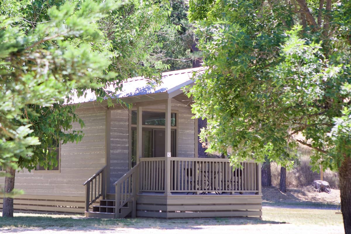 A small cabin with a porch and a number "52" on the door.