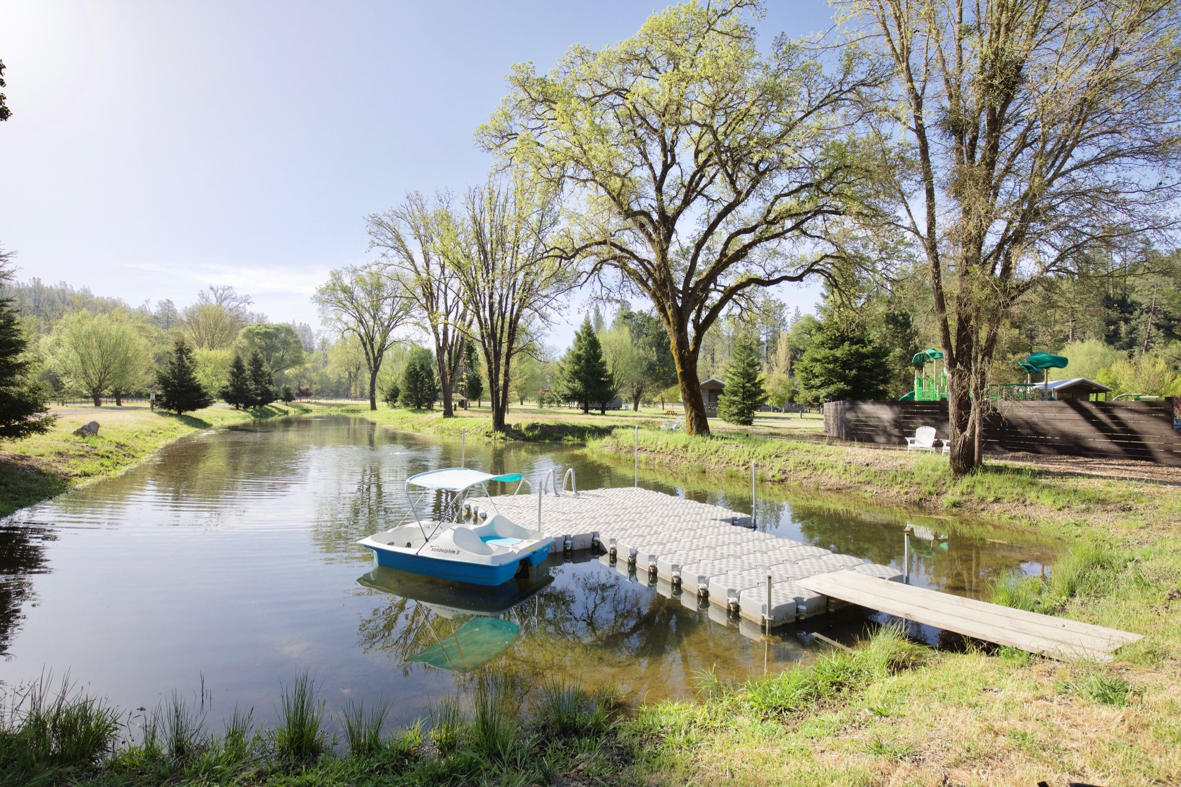 Un río tranquilo con un muelle y un bote.