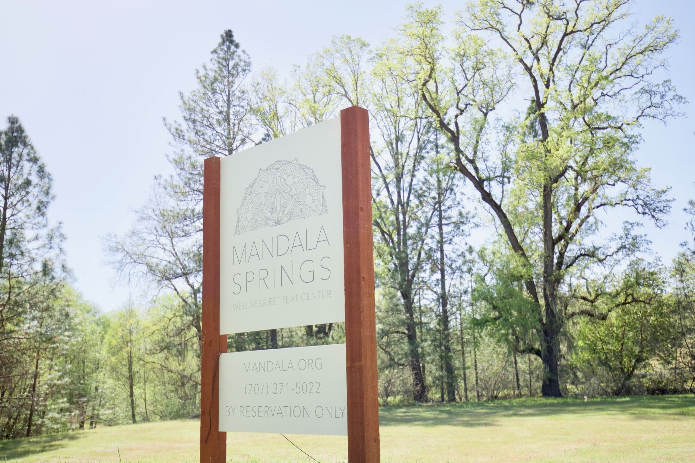 A sign for Mandala Springs Wellness Retreat Center with a contact number and website.