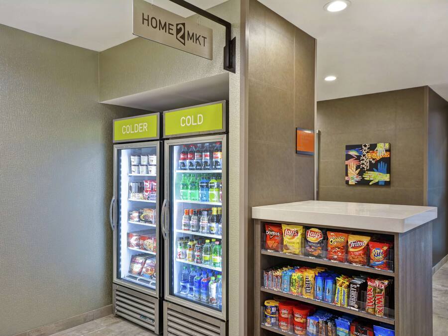 A vending area with two refrigerators labeled "COLDER" and "COLD," stocked with snacks and beverages.