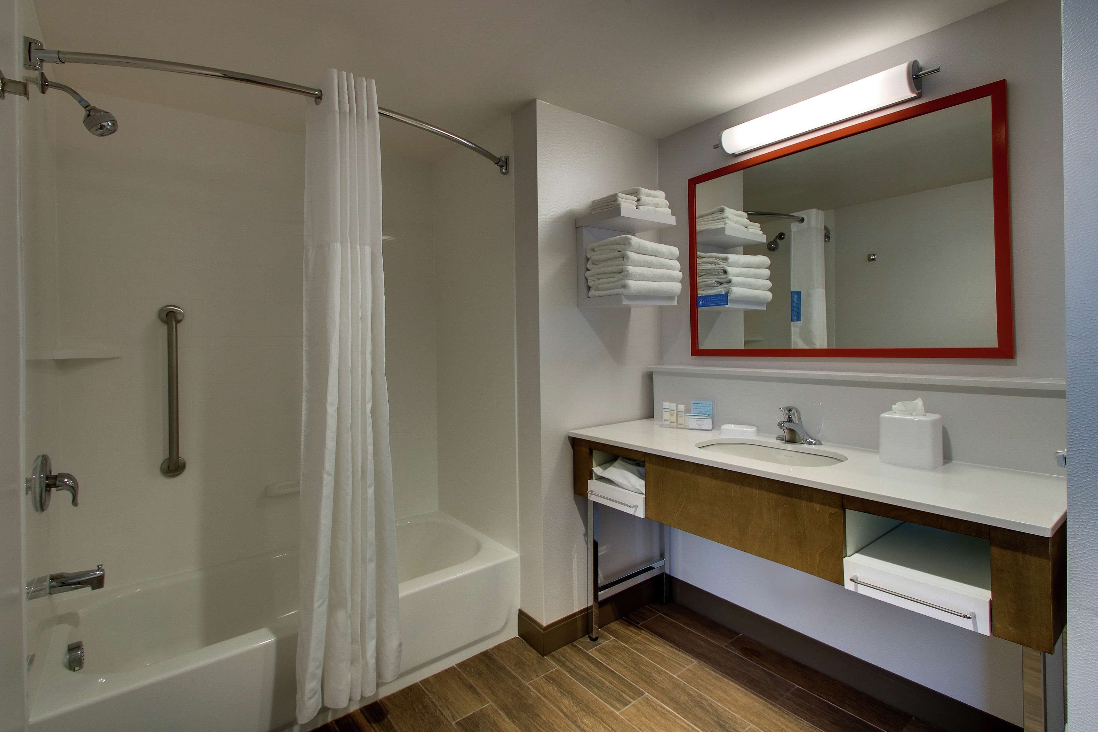Ein Badezimmer mit Dusche, Badewanne, Waschbecken und Spiegel.