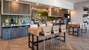 A modern kitchen with a wooden countertop, a coffee machine, and a sign that reads "inspired table".