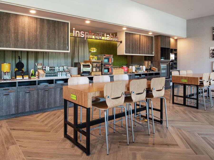 A modern kitchen with a wooden countertop, a coffee machine, and a sign that reads "inspired table".