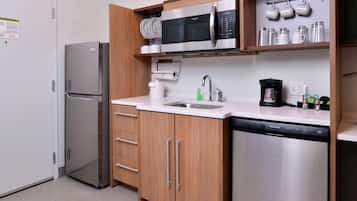 Una cocina moderna con electrodomésticos de acero inoxidable, armarios de madera y lavavajillas integrado.