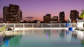 A swimming pool with a city skyline in the background.