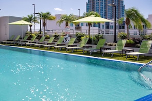 Una piscina al aire libre, sombrillas, tumbonas