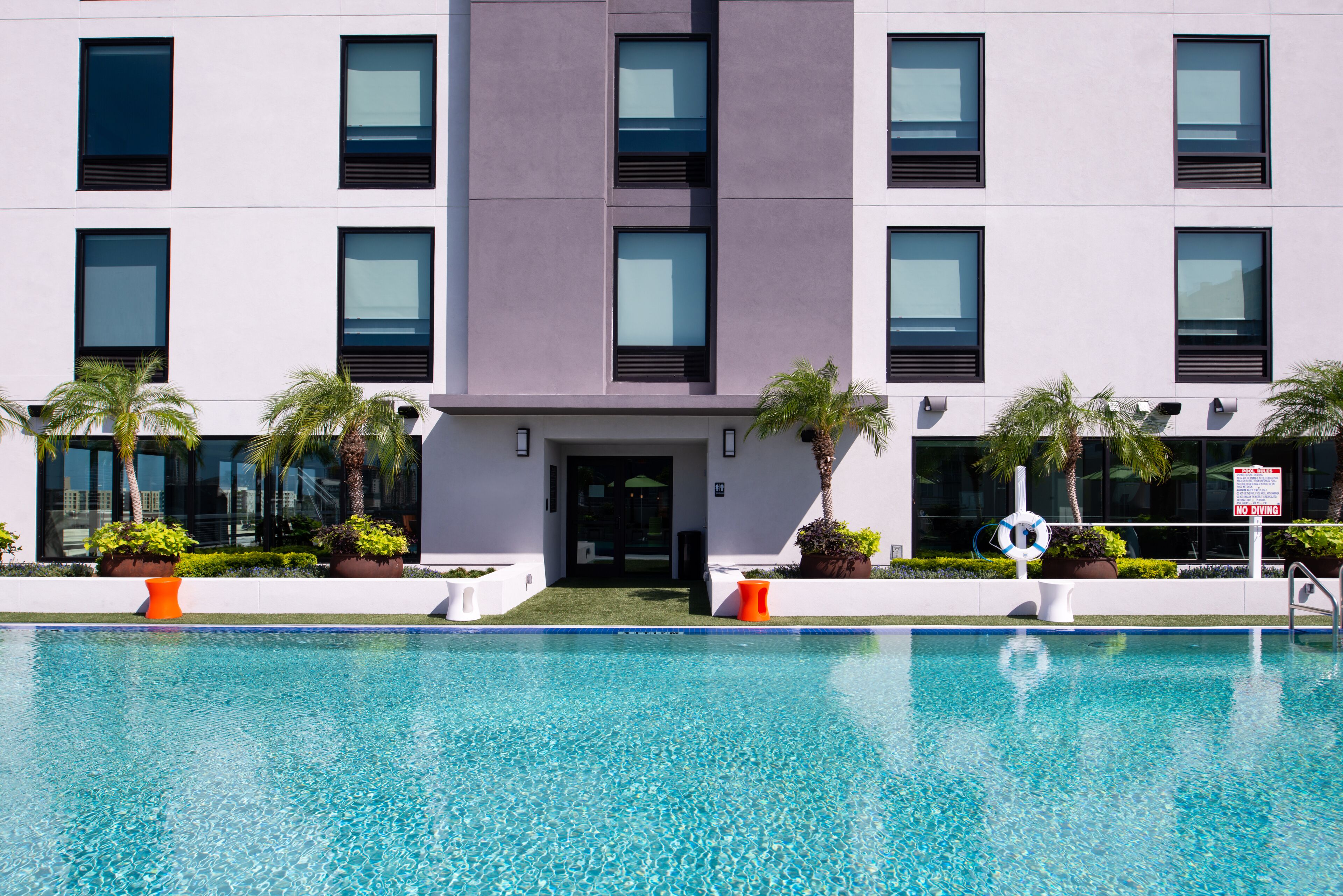 A modern building with a swimming pool in front.