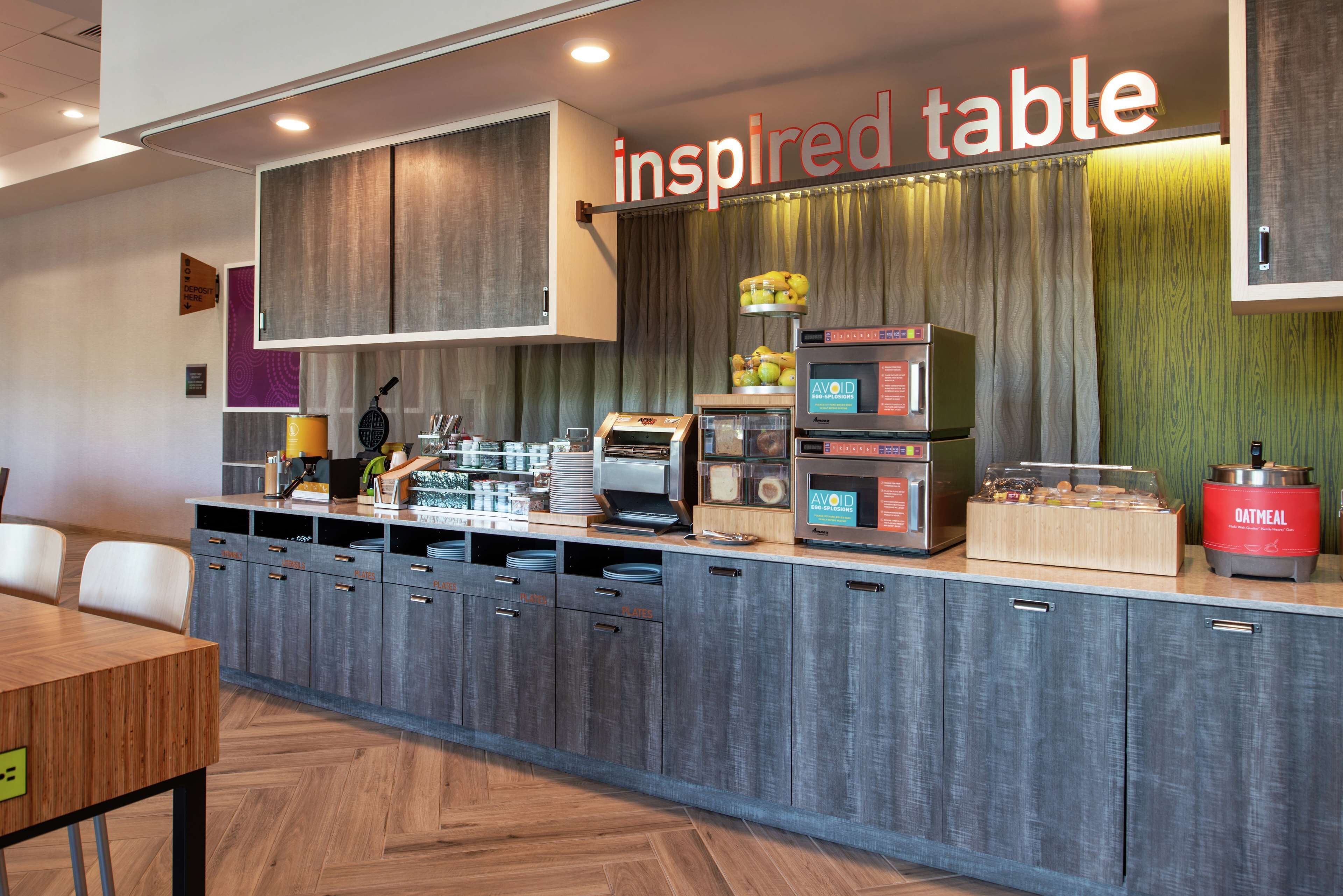 Un espace cuisine moderne avec un comptoir, des appareils électroménagers et un panneau indiquant « table d’inspiration ».