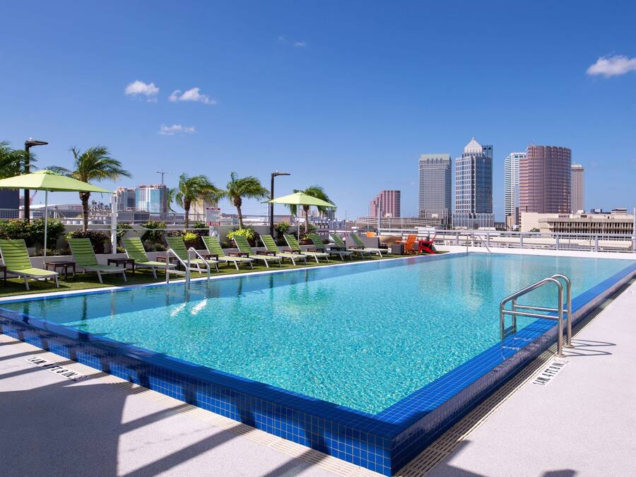 Una piscina al aire libre, sombrillas, tumbonas