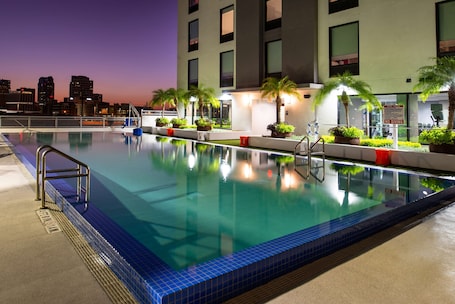 Una piscina al aire libre, sombrillas, sillones reclinables de piscina