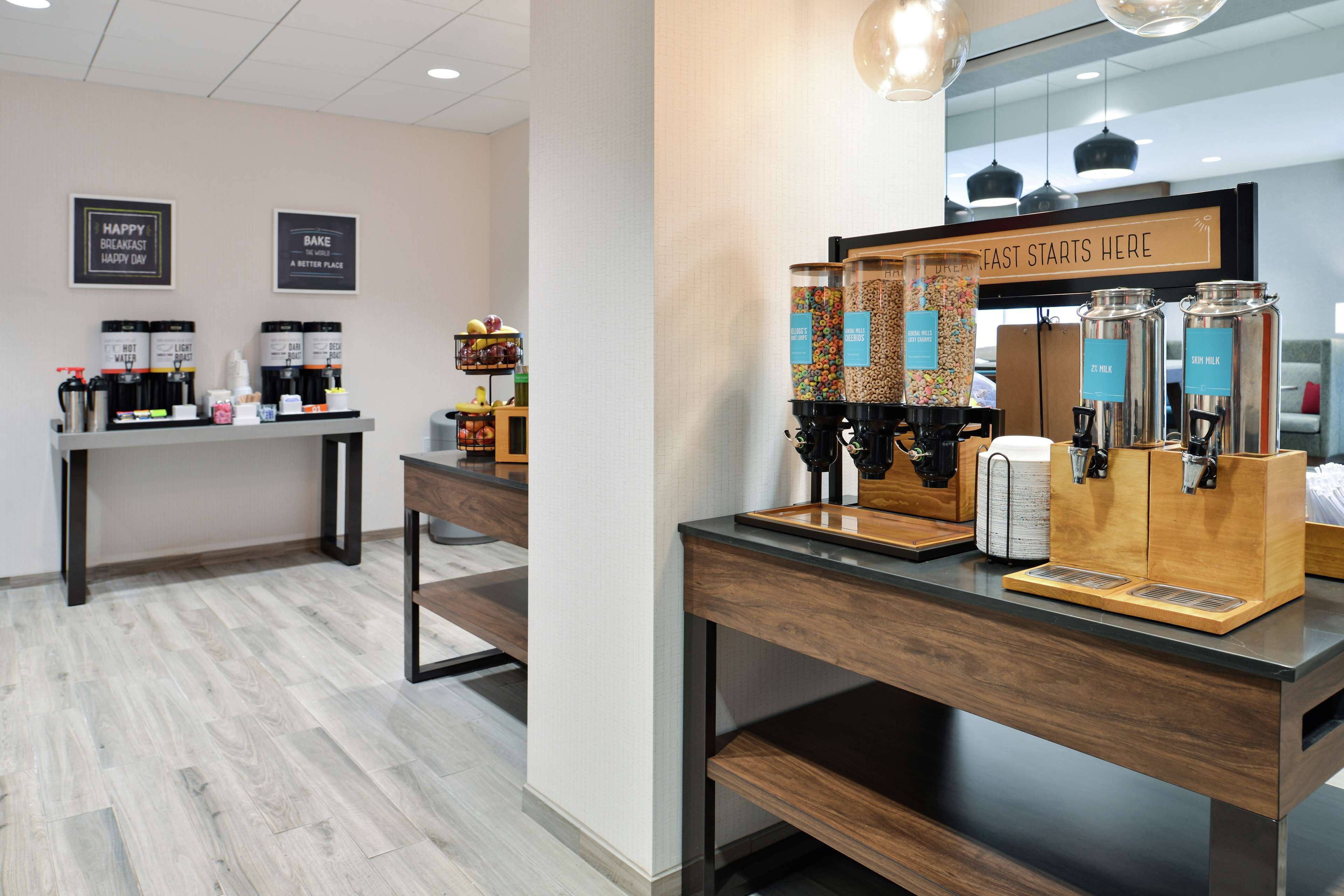 A coffee station with multiple dispensers, a coffee machine, and a sign that reads "FAST STARTS HERE".