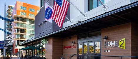 Un hôtel à la façade moderne, avec une enseigne Starbucks et un drapeau américain.