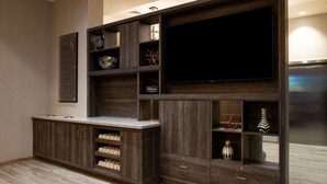 Un salon moderne doté d’un système de divertissement intégré, de meubles en bois et d’un téléviseur à écran plat.
