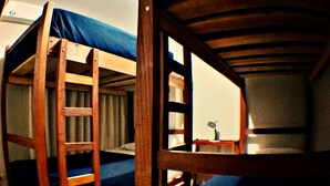Habitación con literas, un escritorio y una silla.