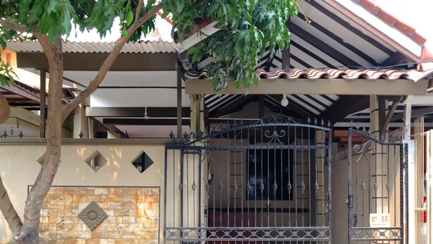 A gated entrance with a tiled wall and a metal gate. - Kamar Keluarga Bandara IV Syariah (Tangerang)