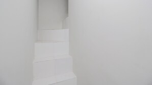A white, minimalist staircase with a clean, modern design. - Kamar Keluarga Bandara IV Syariah (Tangerang)