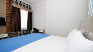 Une chambre d’hôtel avec un lit, un bureau, une chaise et un t éléviseur.