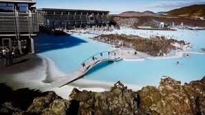 A geothermal spa with pools, a bridge, and a modern building. - Hotel Duus (Reykjanesbær)
