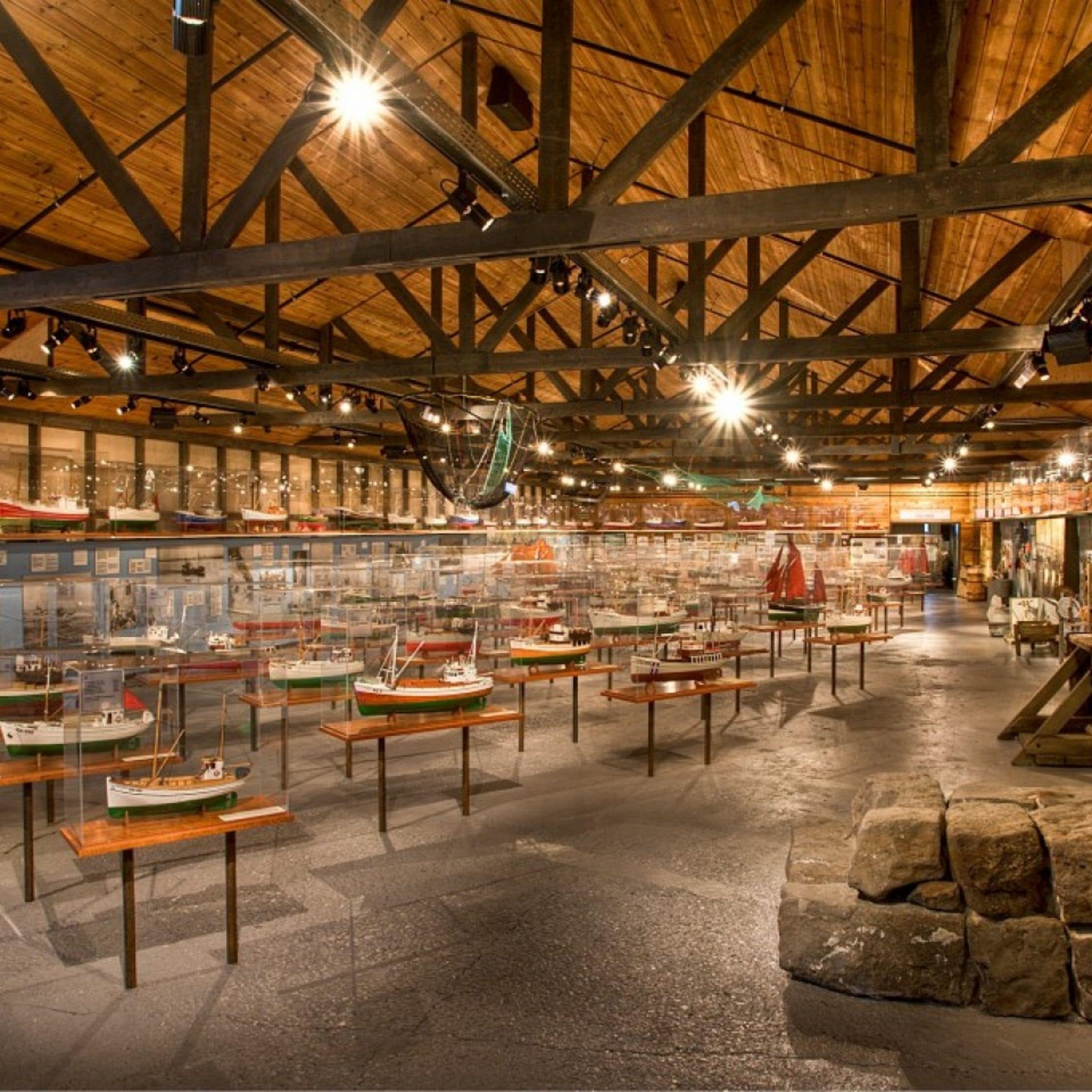 Un museo con vigas de madera y exhibiciones de maquetas de barcos.
