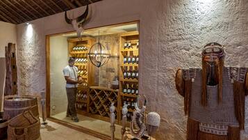 Una habitación con techo de madera, una estantería para vinos y una exhibición de botellas.