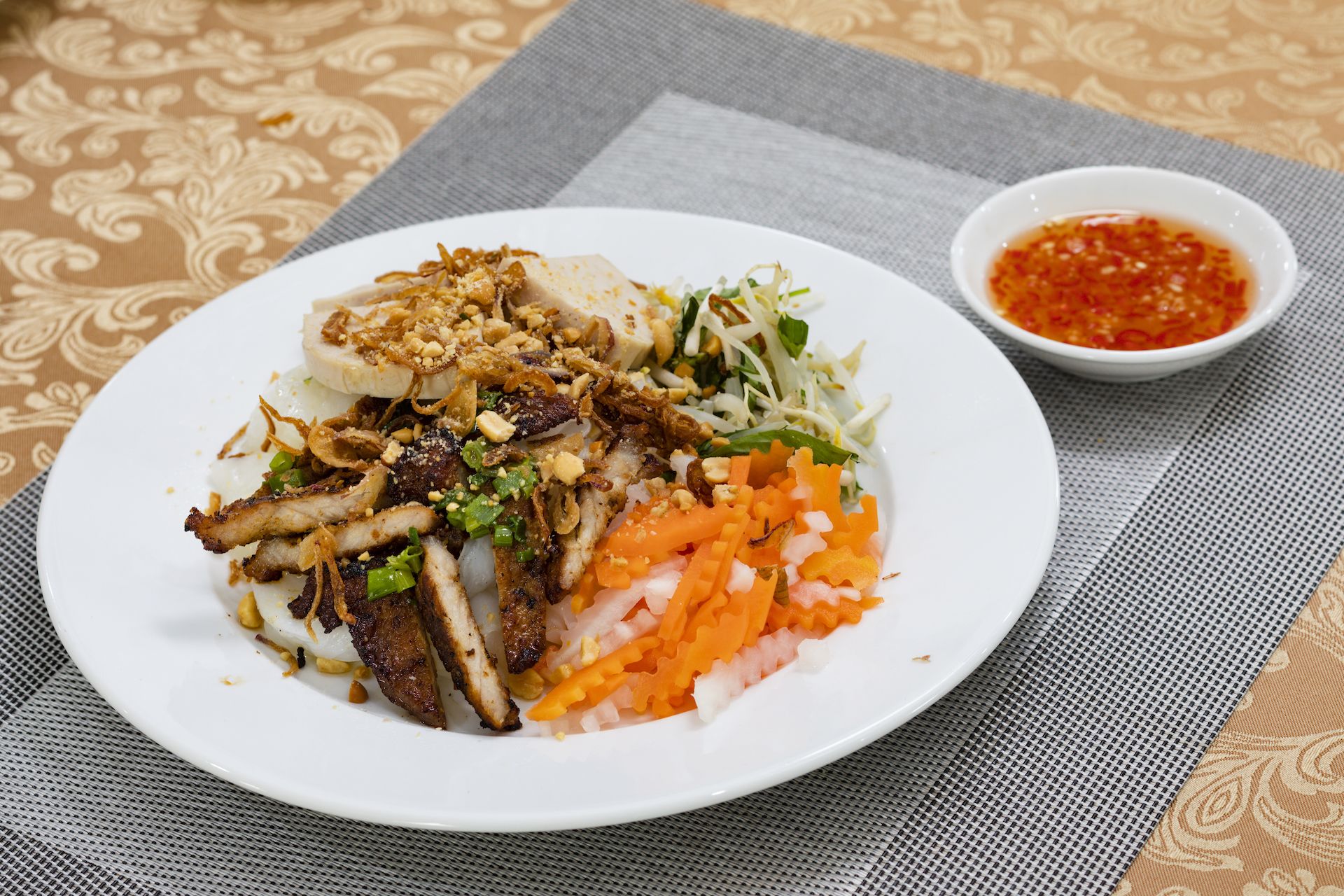 Een bord eten met diverse toppings en een bijpassende dipsaus.