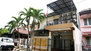 A two-story building with a gated entrance, a balcony, and a flag. - Kamar Keluarga Bandara VII Syariah (Tangerang)