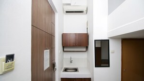 Un baño pequeño con un mueble de madera, un lavabo y un espejo.