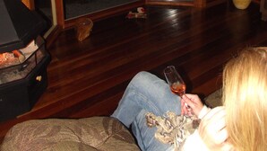 Una stanza con pavimento in legno, un divano, un tavolino in vetro e un'ampia finestra con vista.