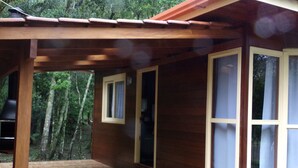 Una baita in legno con veranda coperta e ampie finestre.