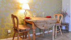 Ein Esstisch mit Stühlen, einer Lampe und einer Blumenvase.