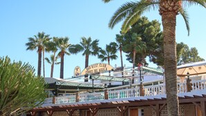 A building with a sign reading "Bar Rest Club Cerros Del Aguila" and a covered outdoor area with a railing. - Cerros del Águila - charming townhouse (Mijas Costa)