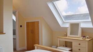 A bedroom with a skylight, a wooden wardrobe, a vanity with drawers, and a bed. - 1 bedroom accommodation in Pembury, near Tunbridge Wells (Pembury, near Tunbridge Wells)