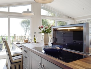 Una cocina moderna con una isla grande, horno empotrado y vistas al exterior.