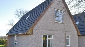 Une maison à deux étages, avec un toit en pente, un petit porche et le chiffre « 3 » bien visible sur le côté.
