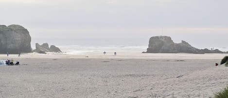 A beach with rocky formations and a clear view of the ocean.