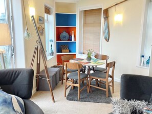 A cozy dining area with a round table, four chairs, and a small side table.